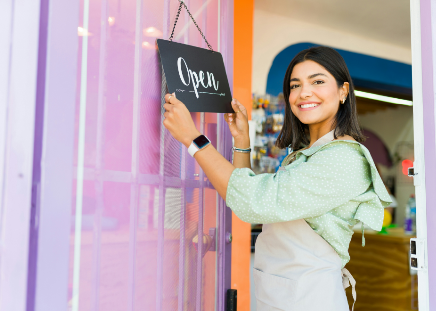 Happy worker adjusting open sign